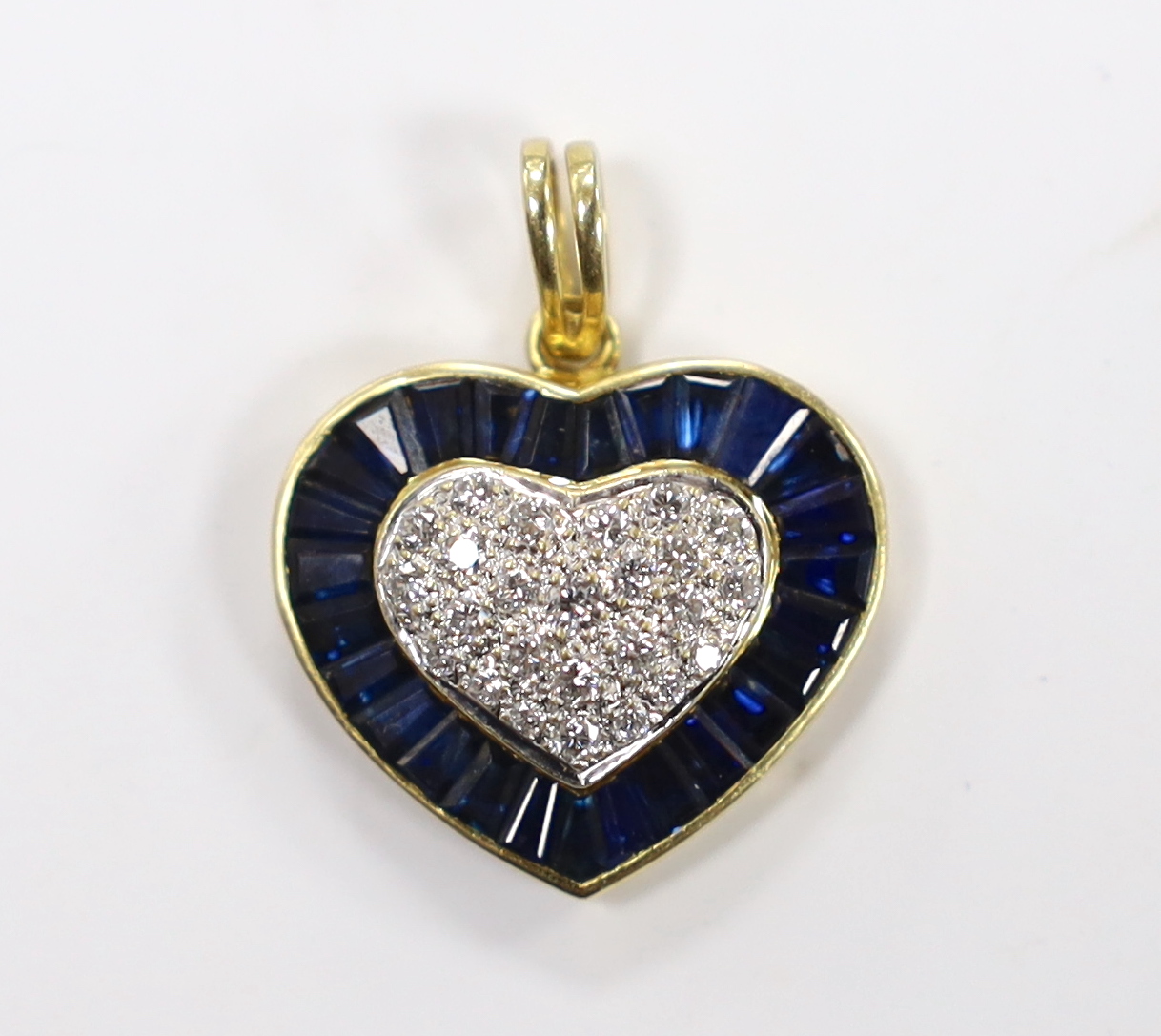 A modern 18k and heart shaped diamond cluster set pendant, with shaped cut sapphire set border, 19mm, gross weight 4.8 grams.